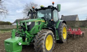 Un tracteur au travail avec une masse à l'avant et une charrue attelée