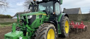 Un tracteur au travail avec une masse à l'avant et une charrue attelée