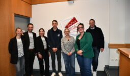 Des personnes dans une salle devant un drapeau jeunes agriculteurs