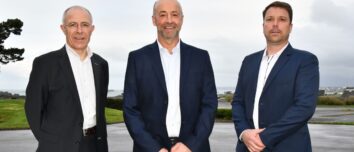 Des personnes en costume posent en extérieur