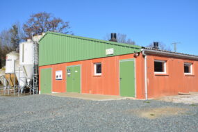 Vue extérieur d'un bâtiment d'élevage porcin avec des silos sur le côté