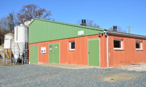 Vue extérieur d'un bâtiment d'élevage porcin avec des silos sur le côté