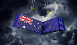 Infographie de 2 containers, un avec le drapeau australien et l'autre avec le drapeau européen. Ils sont suspendus et se cognent dans un ciel d'orage