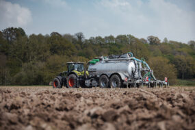 Un tracteur et une tonne à lisier au travail dans un champ