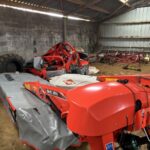 Du matériel de fauche d'herbe dans un hangard