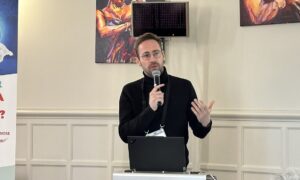 Un homme dans une salle en train de parler avec un micro à la main