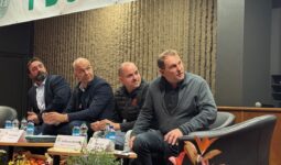 Quatre homme assis autour d'une table regardent sur leur gauche