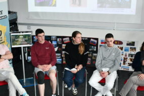 des hommes et des femmes assis en table ronde