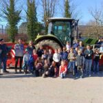 Des enfants et des personnes devant un tracteur