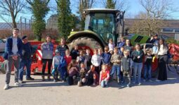 Des enfants et des personnes devant un tracteur