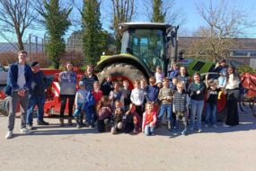 Des enfants et des personnes devant un tracteur