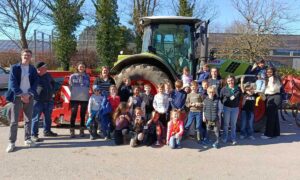 Des enfants et des personnes devant un tracteur