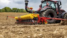 Un semoir Tempo de la marque Väderstad enrichit de nouveaux réglages en cabine et d’automatismes, attelé à un tracteur dans un champ