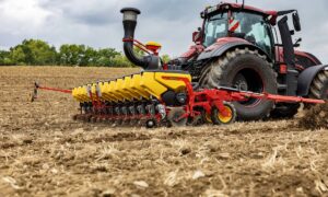 Un semoir Tempo de la marque Väderstad enrichit de nouveaux réglages en cabine et d’automatismes, attelé à un tracteur dans un champ
