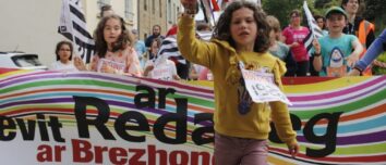 Une fillette devant une banderolle lors du départ d'une course de relais à pieds avec le bâton témoin à la main