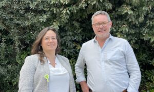 un homme et une femme devant une haie