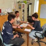 Deux hommes et une femme en réunion autour d'une table