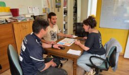 Deux hommes et une femme en réunion autour d'une table