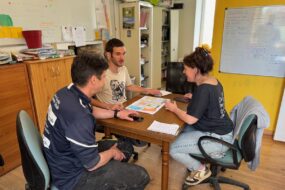 Deux hommes et une femme en réunion autour d'une table