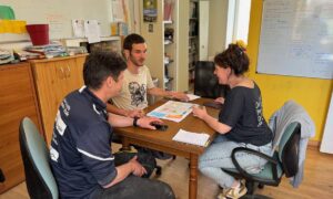 Deux hommes et une femme en réunion autour d'une table