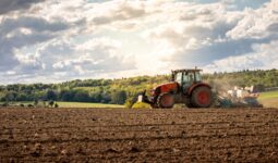 Un tracteur en train de labourer dans un champ au printemps
