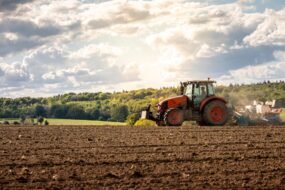 Un tracteur en train de labourer dans un champ au printemps