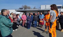 Des personnes regroupées sur un parking en train d'écouter une autre qui parle
