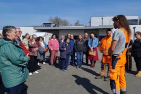 Des personnes regroupées sur un parking en train d'écouter une autre qui parle