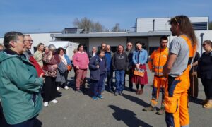Des personnes regroupées sur un parking en train d'écouter une autre qui parle