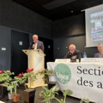 Une personne parle dans un micro derrière un pupitre lors d'une assemblée