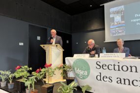 Une personne parle dans un micro derrière un pupitre lors d'une assemblée