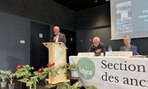 Une personne parle dans un micro derrière un pupitre lors d'une assemblée