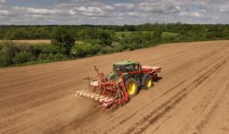 Vue aérienne d'un tracteur en train de semer du maïs dans un champ