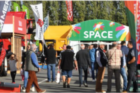 des visiteurs dans les allées extérieures d'un salon agricole