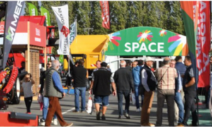 des visiteurs dans les allées extérieures d'un salon agricole