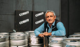 Un homme pose au milieu de fûts de bière Coreff