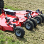Un gyrobroyeur attelé à un tracteur dans un champ