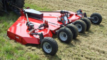 Un gyrobroyeur attelé à un tracteur dans un champ