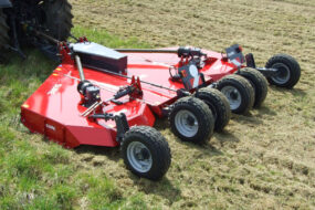 Un gyrobroyeur attelé à un tracteur dans un champ