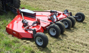 Un gyrobroyeur attelé à un tracteur dans un champ