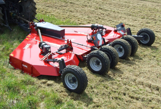 Un gyrobroyeur attelé à un tracteur dans un champ