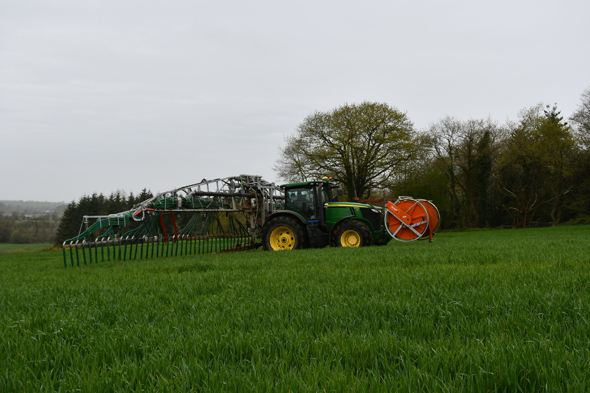 Le tracteur avec la rampe à l’arrière alimentée par un tuyau souple.