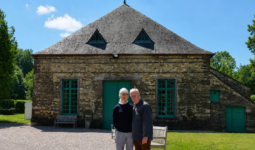 Un homme et une femme devant un bâtiment en pierre rénové