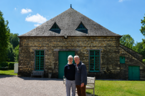 Un homme et une femme devant un bâtiment en pierre rénové