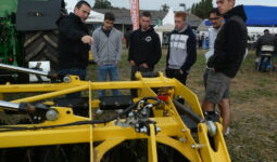 Des personnes en train d'observer un matériel agricole lors d'un salon