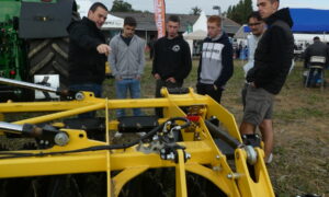 Des personnes en train d'observer un matériel agricole lors d'un salon