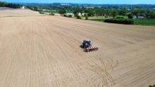 vue drone d'un tracteur en train de semer du maïs