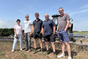 Un groupe de personnes dans un champ devant un tracteur