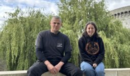 Un homme et une femme assis sur un mur devant un saule pleureur