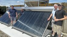 Des hommes devant une installation solaire thermique